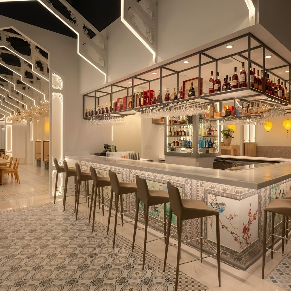 Elegant restaurant bar with a long counter, stools, stocked shelves, and decorative patterned floor and bar front.